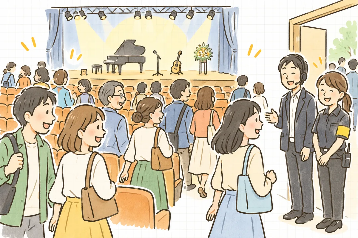 終演後、照明が明るくなったホールで、来場者が笑顔で席を立ち、出口近くで制作ディレクターとスタッフが穏やかに見送っている